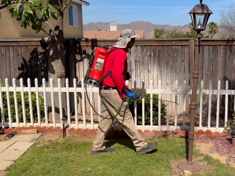Bull's Eye Pest Control technician treating a Lake Elsinore, CA backyard fence line