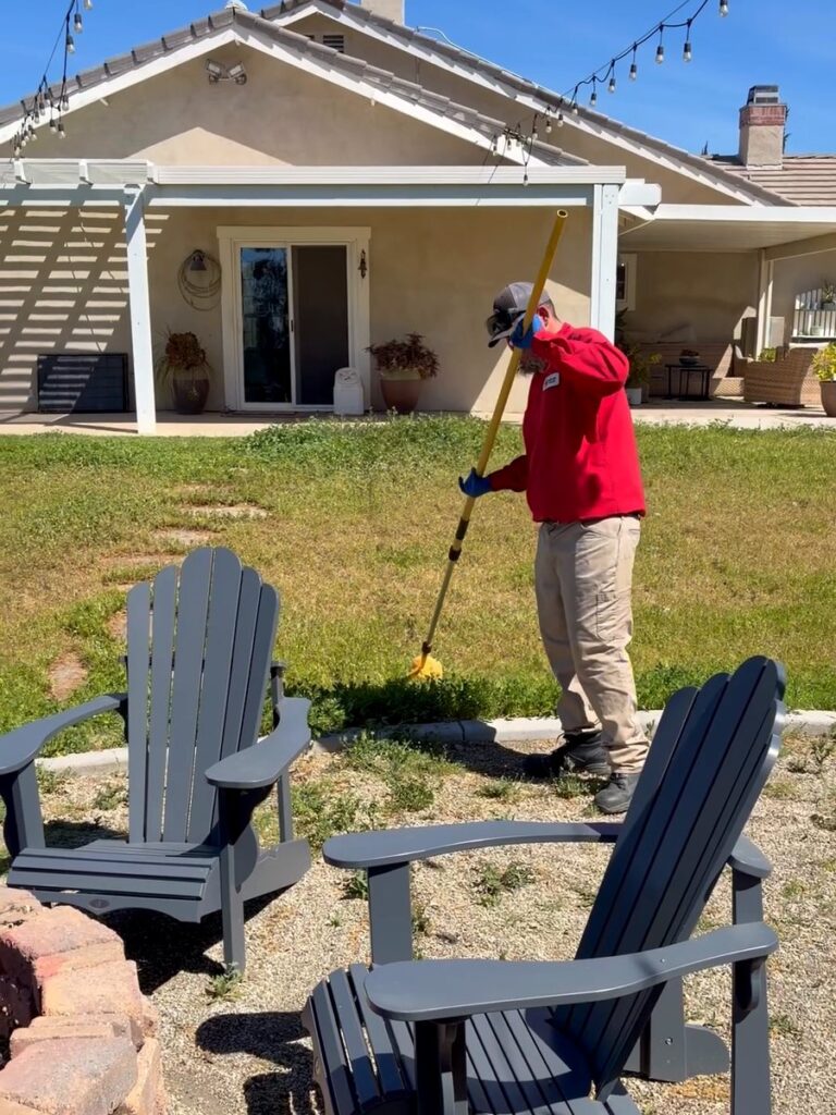 Bull's Eye Pest Control technician treating the backyard of a large-lot Wildomar, CA home
